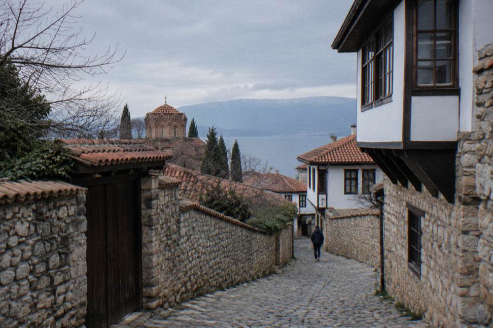 A narrow stone lane in Ohrid old town winding uphill between old stone walls