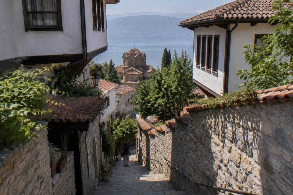 Stone courtyard walls and a narrow stairway between old houses in Ohrid