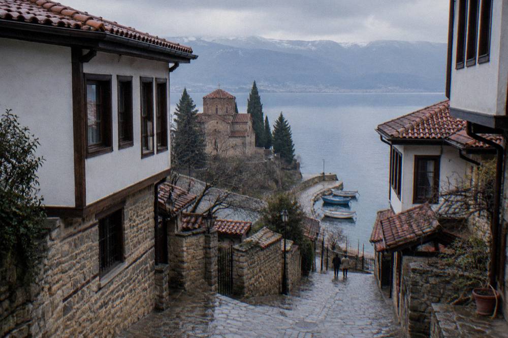 Small boats moored along the stone quay beside Lake Ohrid in the morning
