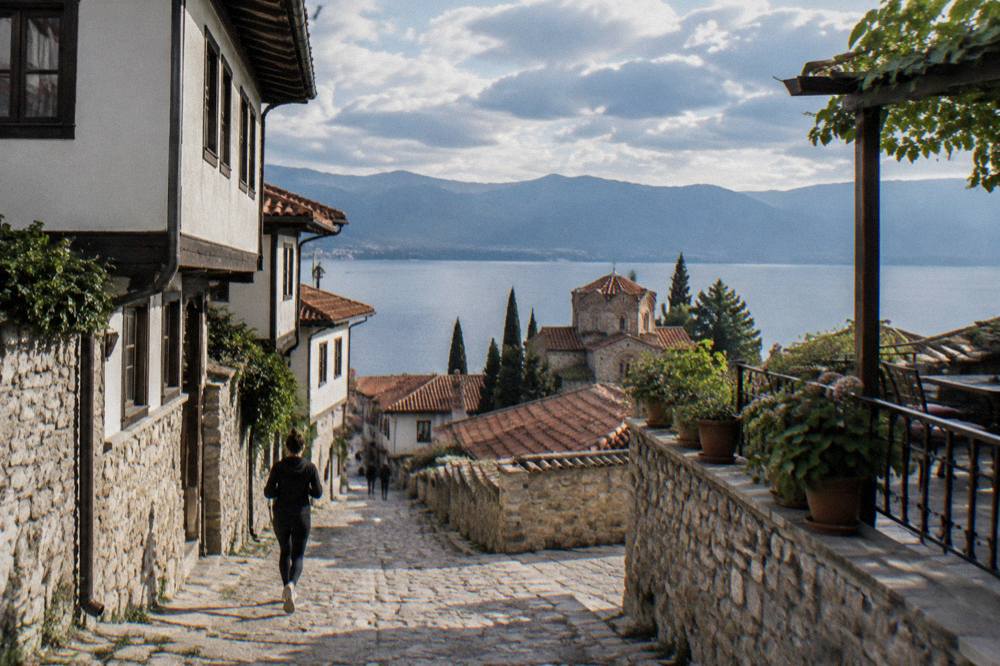 A guesthouse terrace above the rooftops of Ohrid with the lake on the horizon