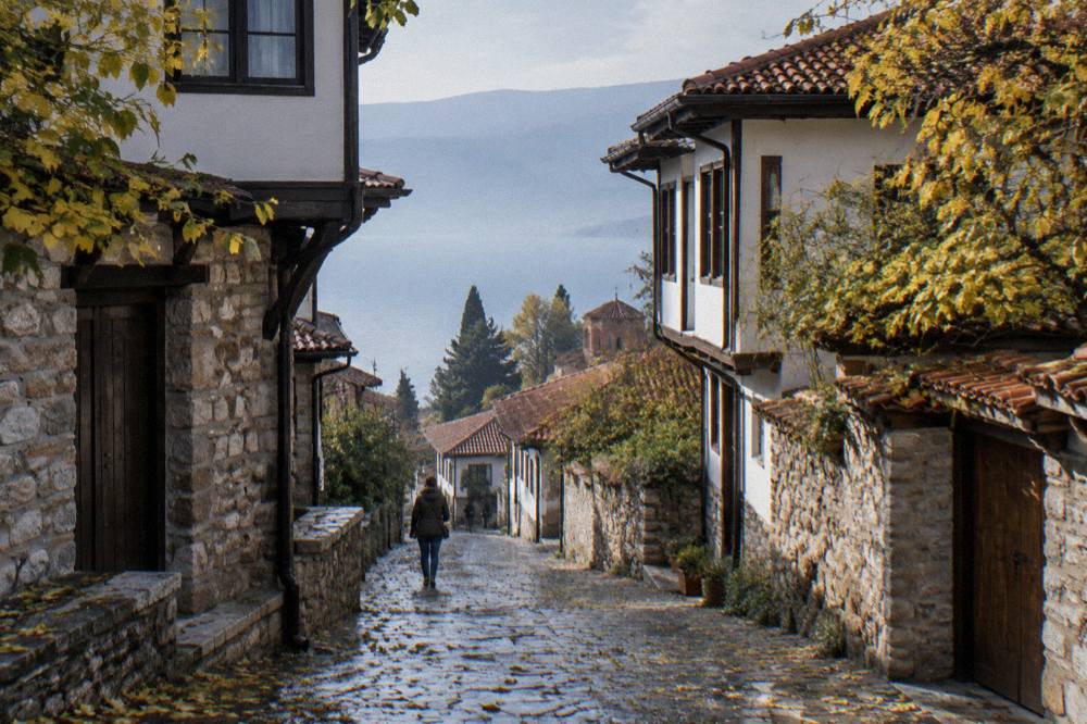 Autumn leaves along a stone lane in Ohrid's old town on a mild afternoon