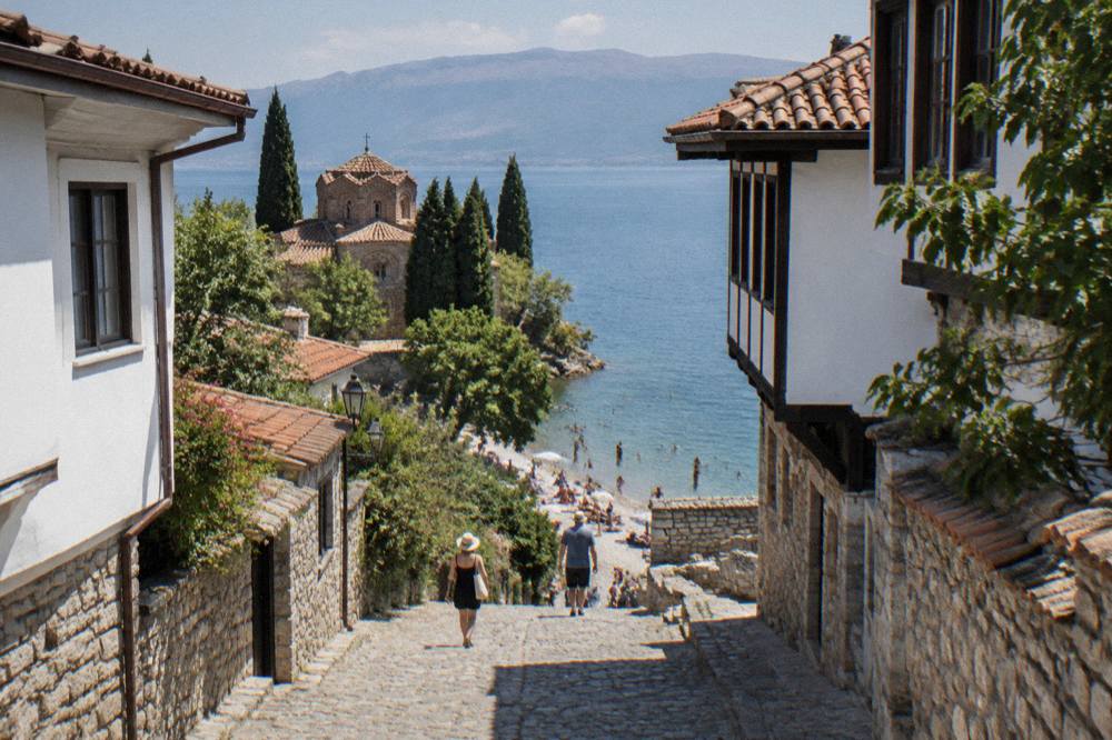 People swimming from a pebble beach on the shore of Lake Ohrid on a sunny afternoon
