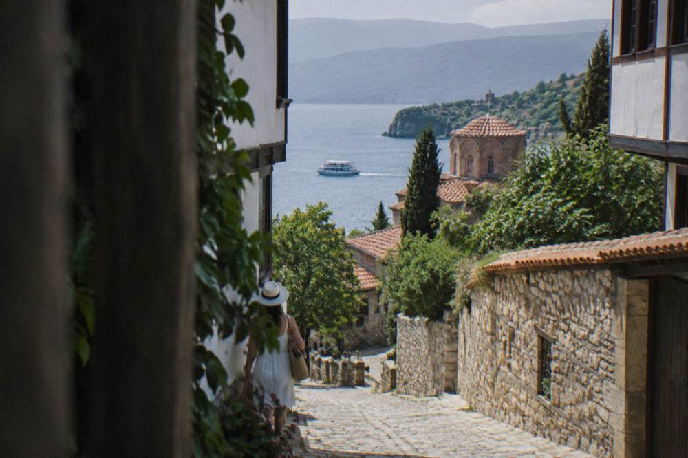 A small cruise boat crossing Lake Ohrid towards the southern monastery shore