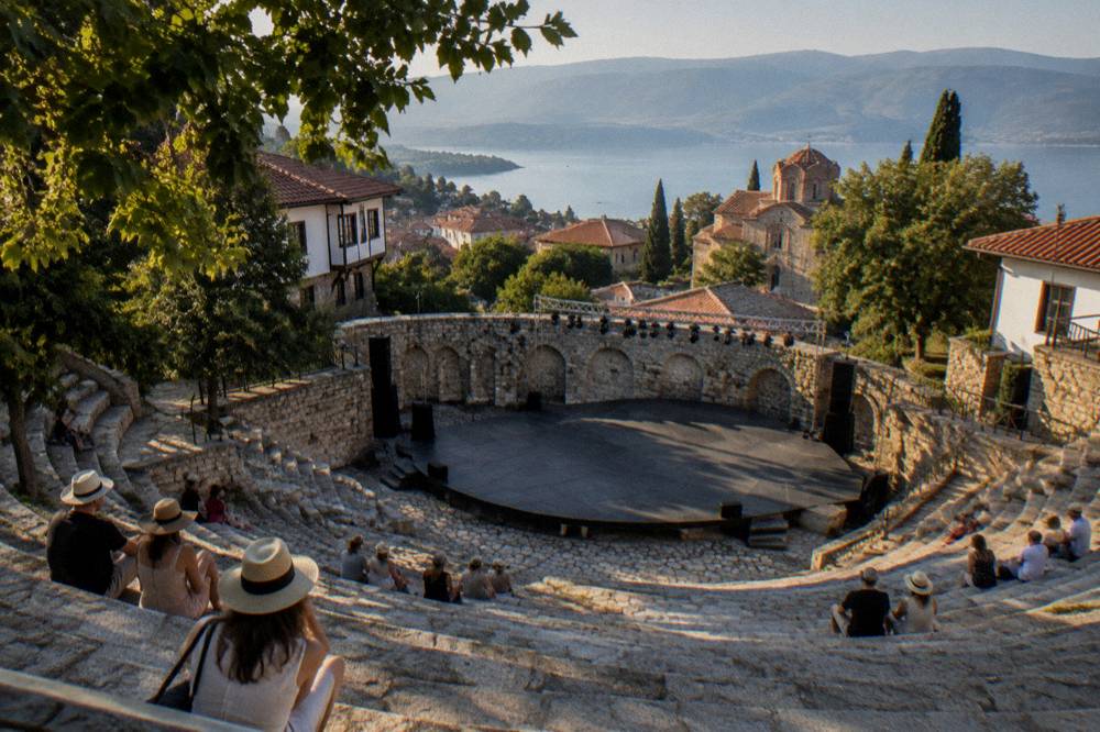 An open-air stone theatre stage prepared for an evening summer performance in Ohrid