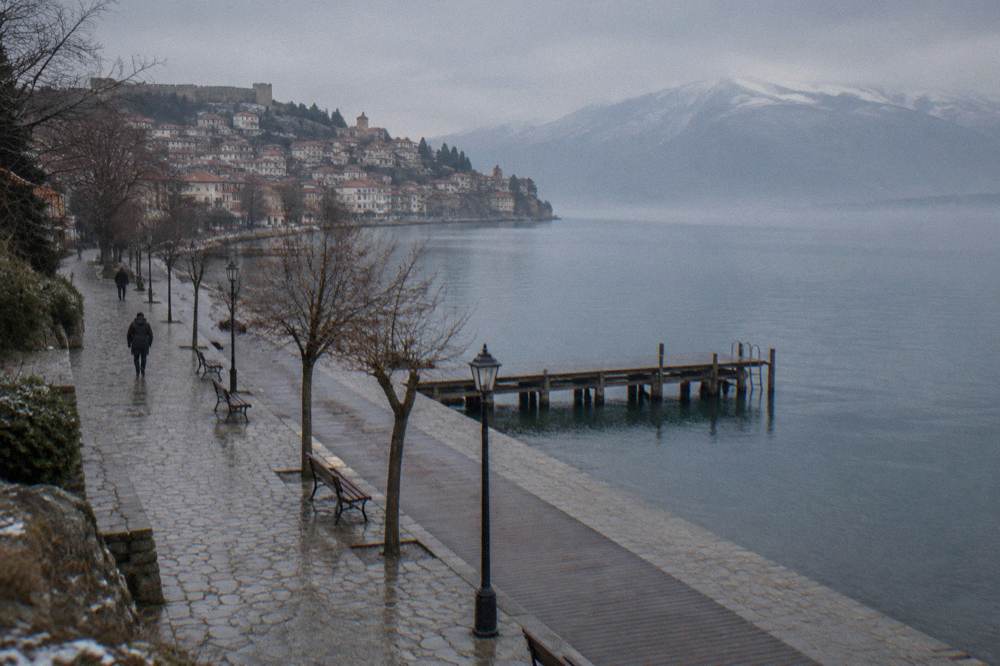 An empty lakeside promenade in Ohrid in winter with calm grey water