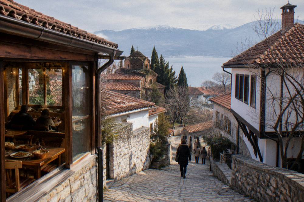 A warm restaurant interior in Ohrid with wooden tables and traditional Macedonian dishes
