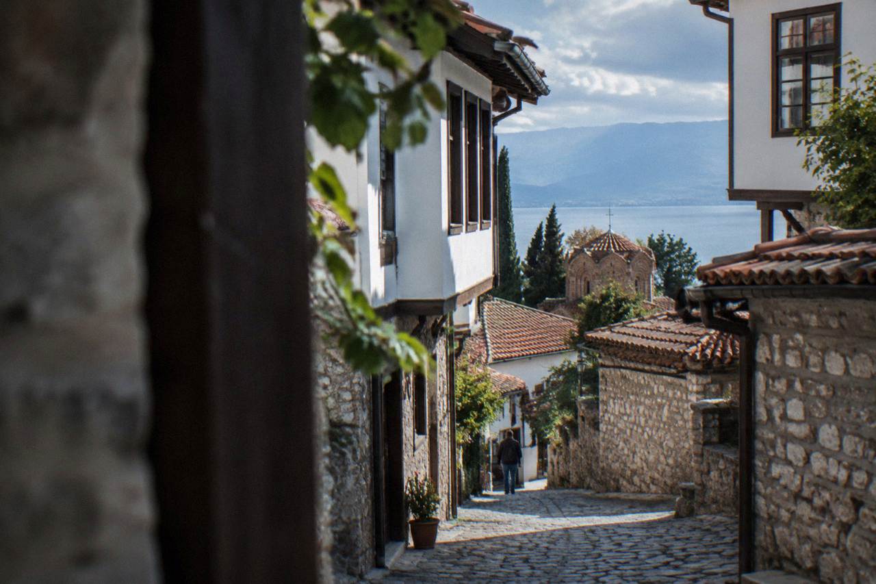 A stone lane in Ohrid old town with a shop sign written in Cyrillic lettering