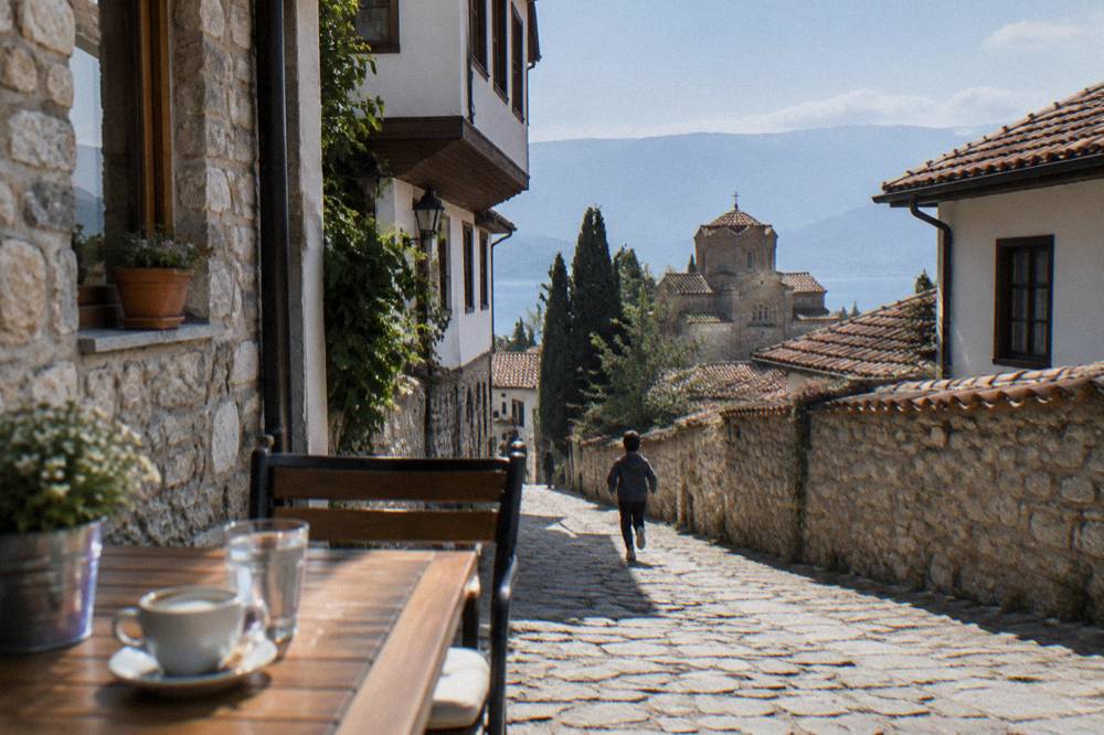 An outdoor cafe table in Ohrid with a menu standing beside glasses of wine