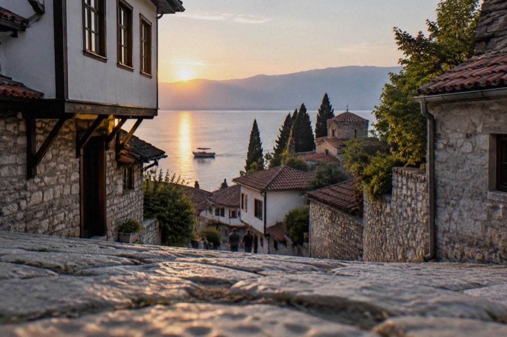A small boat on Lake Ohrid at sunset near the Ohrid shoreline