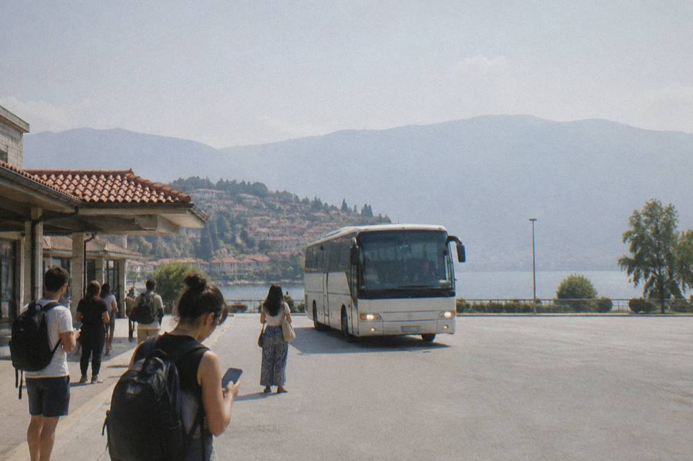 A bus arriving at Ohrid bus station with passengers holding phones