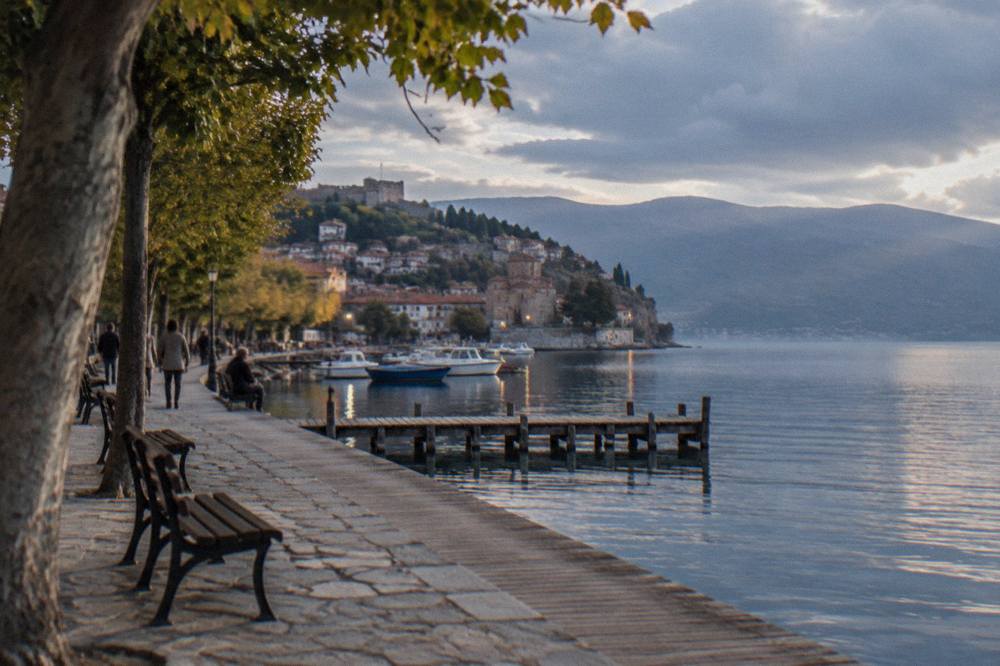 Evening lights along the Ohrid lakeside quay with boats moored at a pier