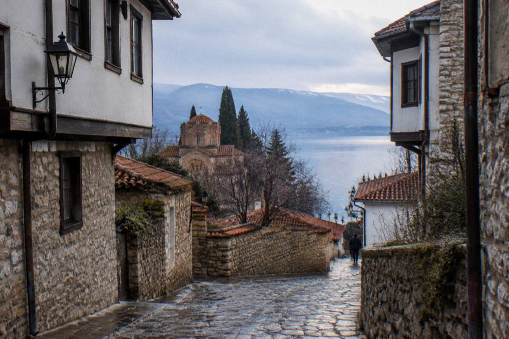 A quiet lakeside path in Ohrid in late afternoon light with distant hills