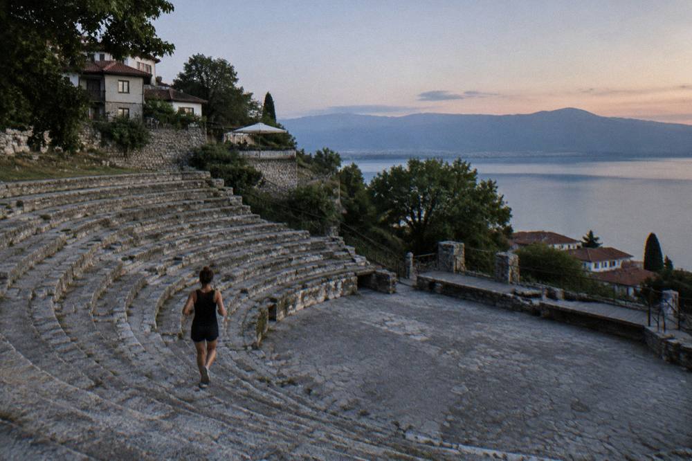 Guesthouse terraces with lake views on a hillside above a shoreline at sunset