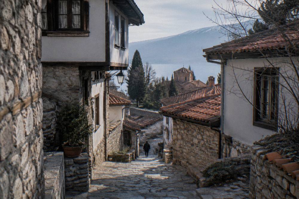 A narrow stone lane in Ohrid old town with stone steps climbing between old houses
