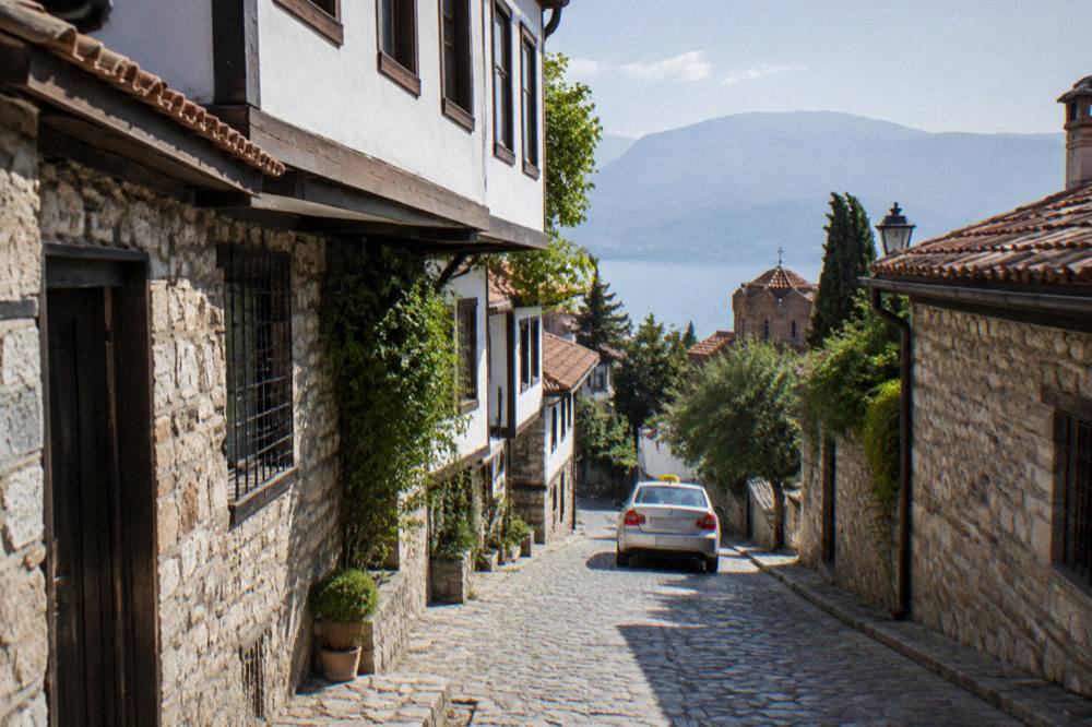 A street in Ohrid in the morning with a taxi passing old stone houses