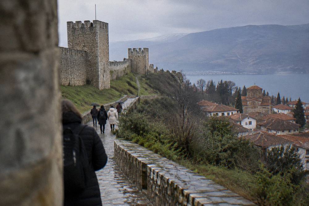 Visitors walking the stone lane below the walls of Samuel's Fortress in Ohrid old town