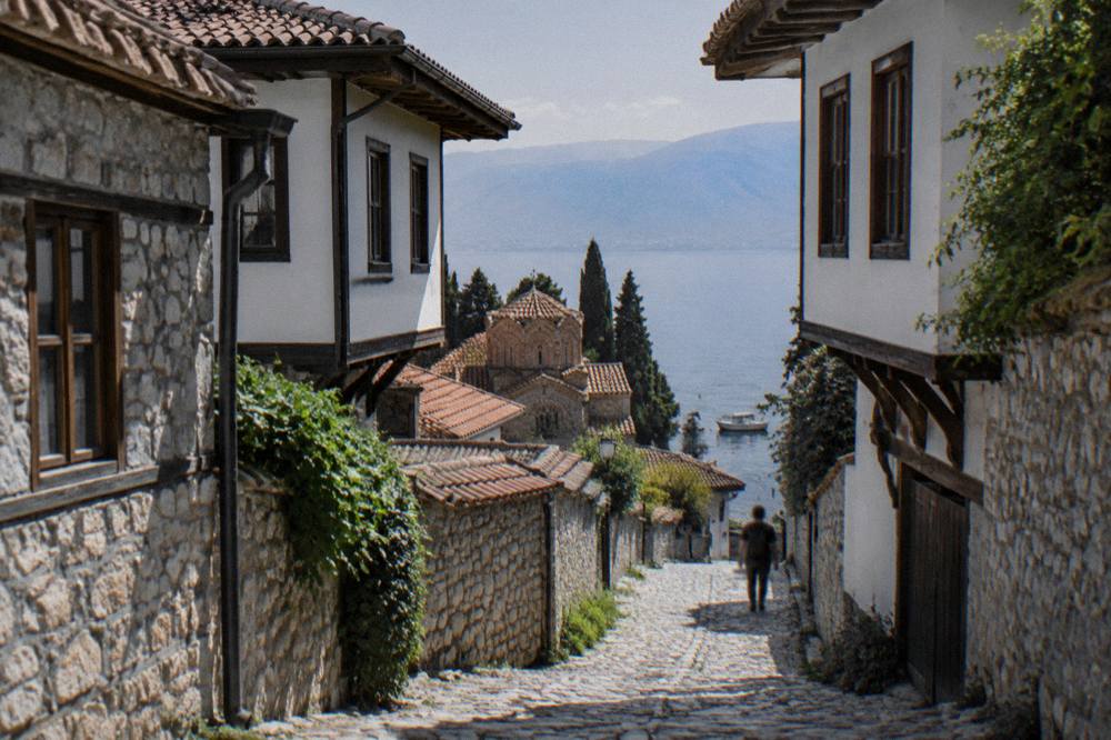 Small boats moored in clear green water along the Ohrid lakeshore in the evening