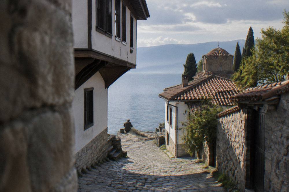 Fisherman mending nets on the shore of Lake Ohrid in early morning light