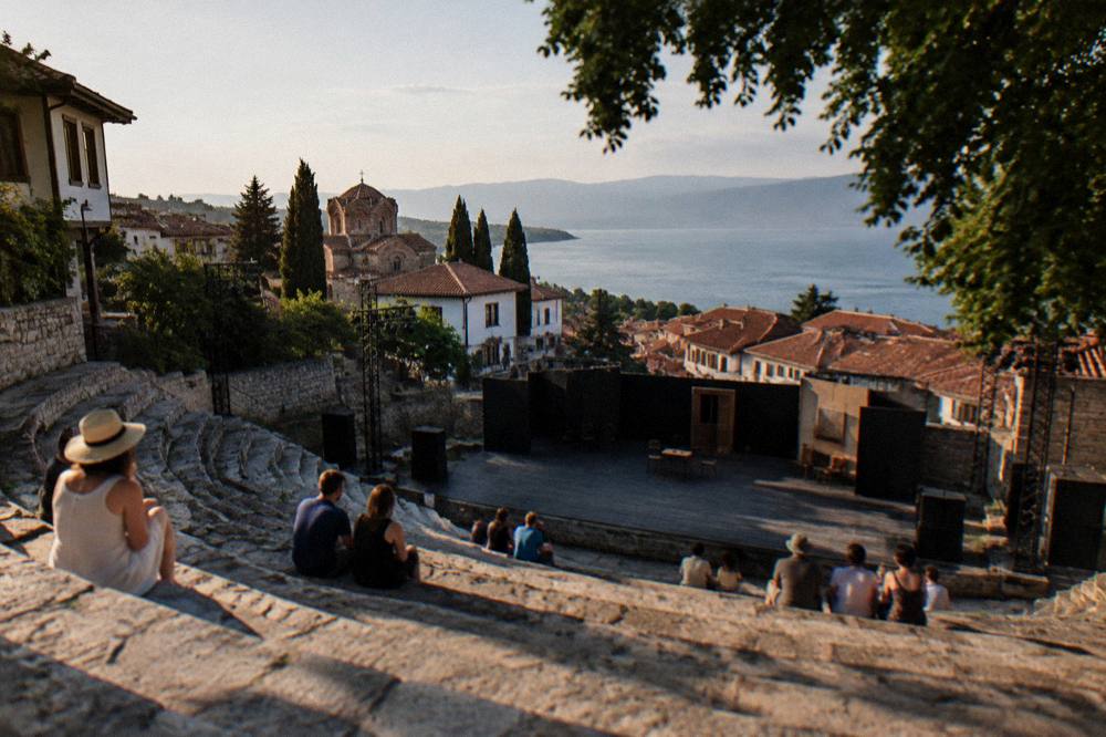 An open-air stone theatre stage set for an evening performance