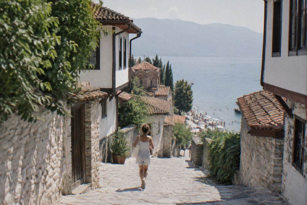 Swimmers and sunbathers on a crowded pebble beach at Lake Ohrid in summer