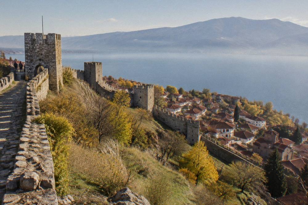 Golden autumn light over Lake Ohrid with the old town and fortress walls above the shore
