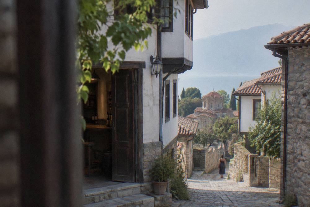 A stone lane in Ohrid old town with an open door onto a tasting room