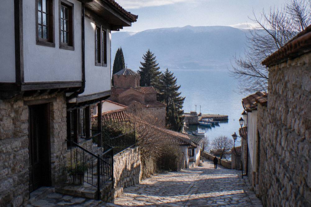 Small boats moored in clear water near a stone jetty on Lake Ohrid