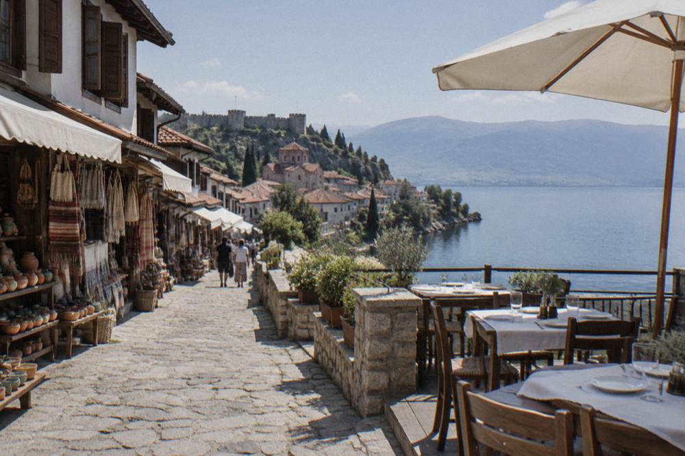 An outdoor restaurant terrace above a lake with tables set for lunch