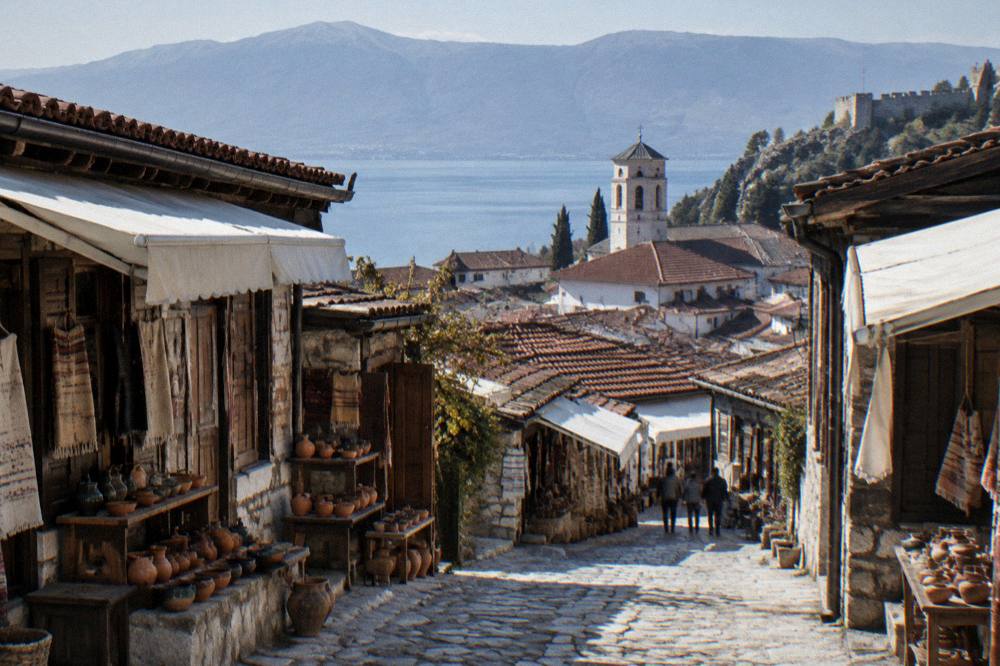A stone lane in an old lakeside town with a church tower above the rooftops