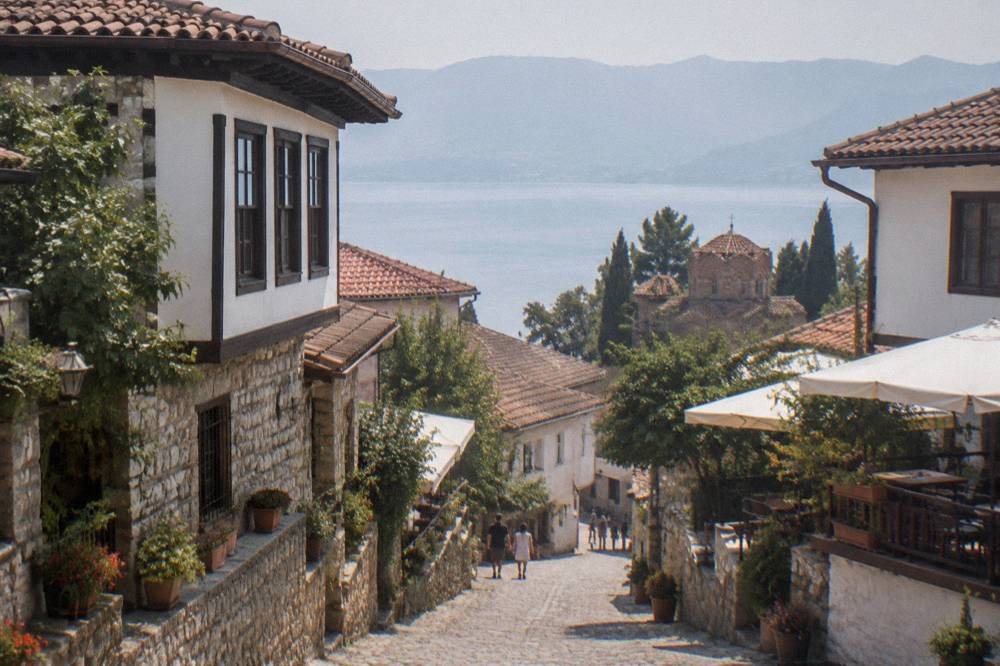 A cobbled Ohrid street lined with traditional stone houses and restaurant terraces