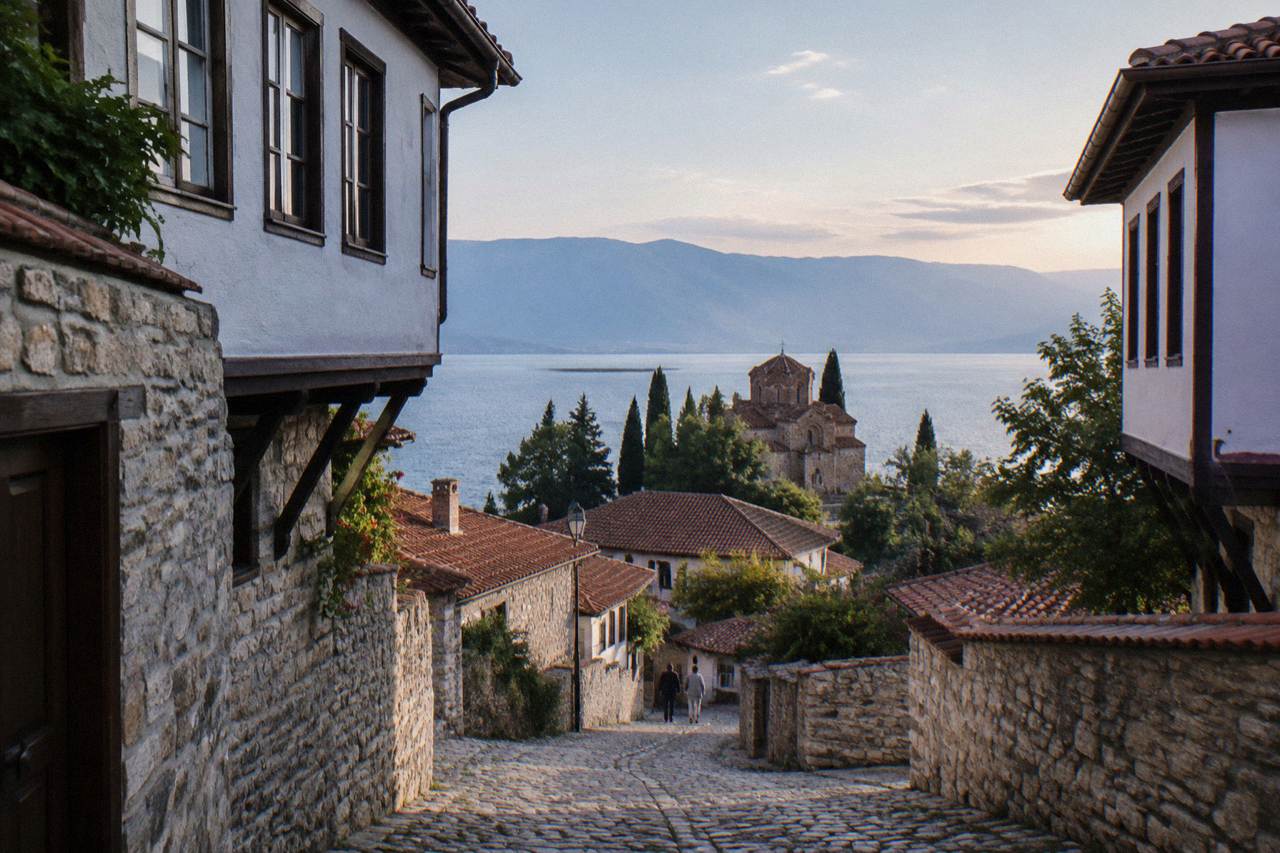 Ohrid old town and lake shore illuminated at dusk with church silhouettes above the water