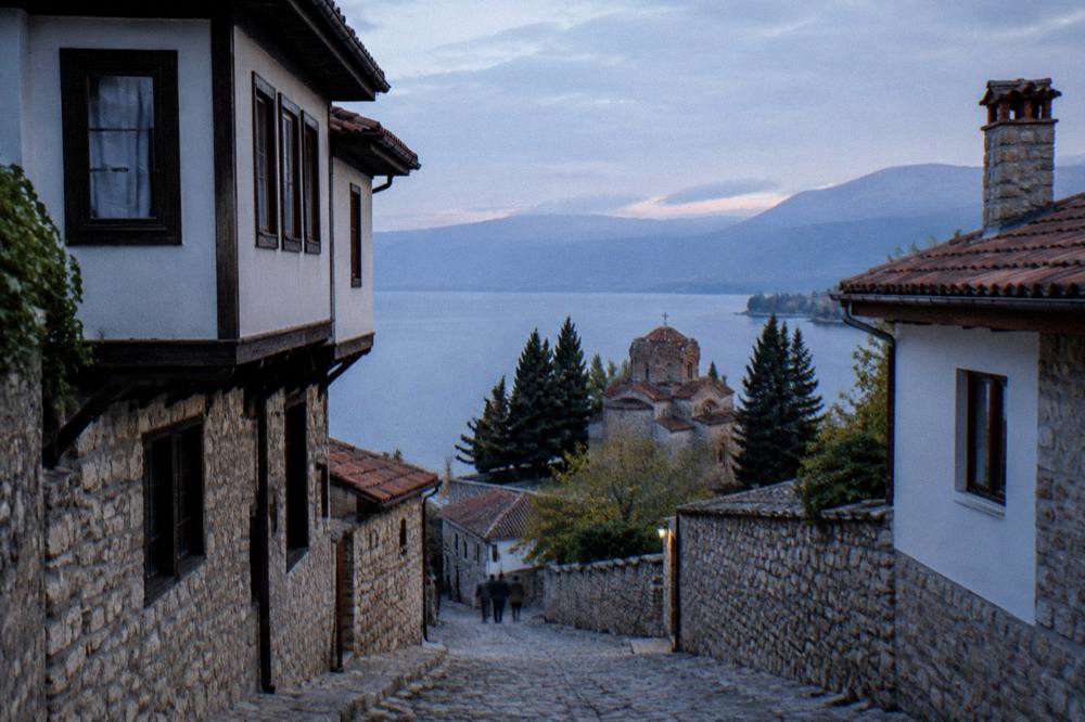 A couple sharing a map at a stone viewpoint above Ohrid and the wide lake