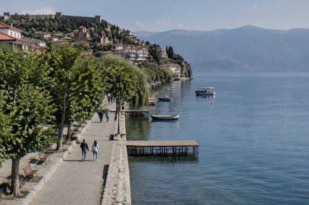The stone boardwalk along Lake Ohrid with small boats moored at the town port