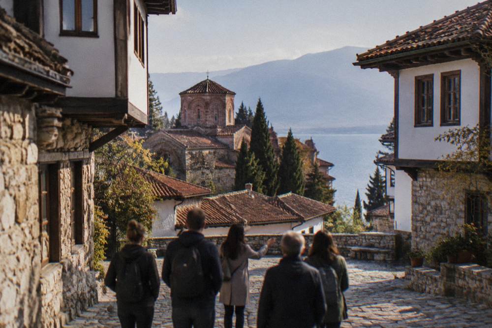 A small group of walkers with a guide on a stone square in Ohrid old town