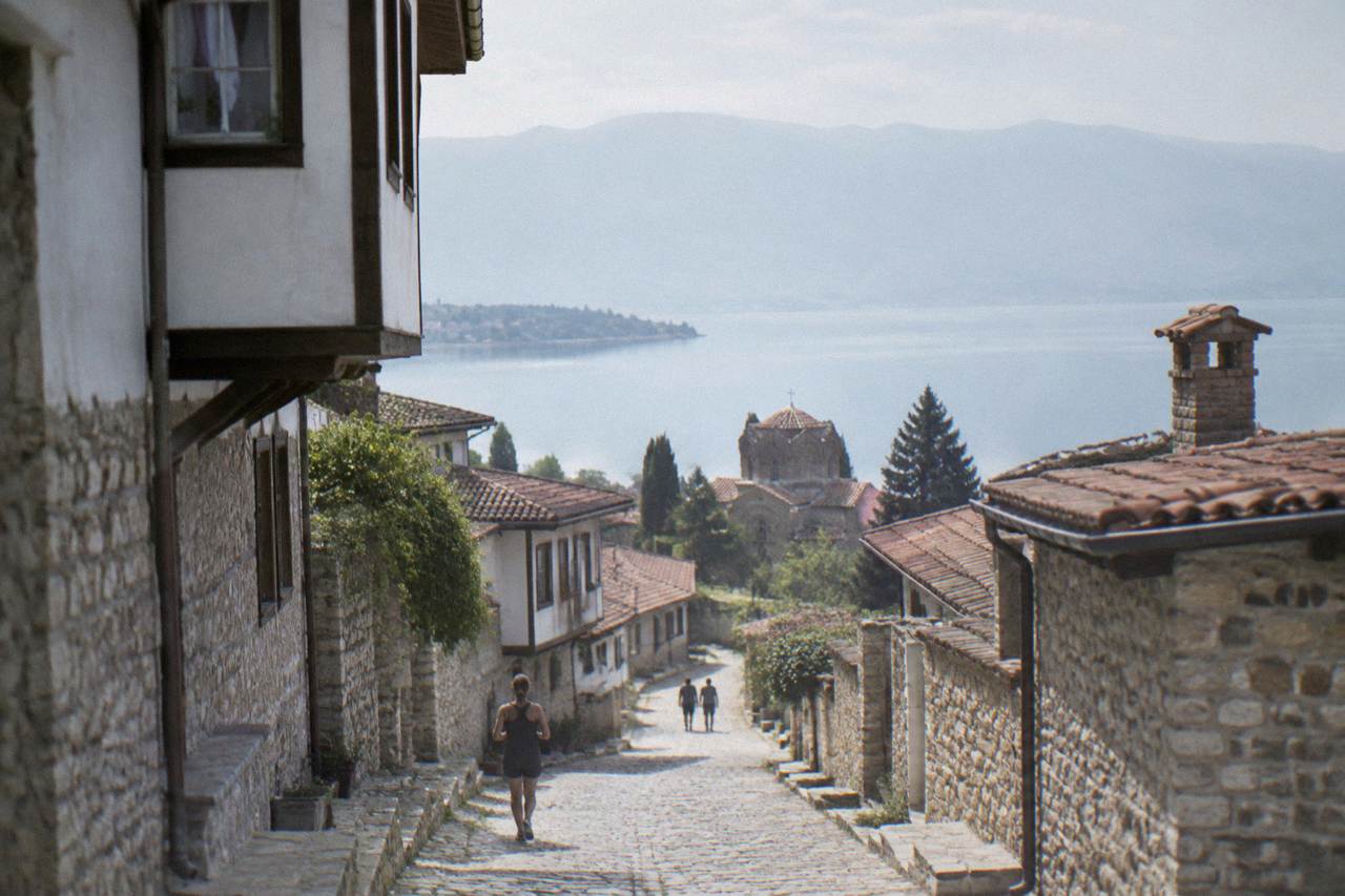 Stone houses of Ohrid old town stacked on a hillside above the blue water of Lake Ohrid