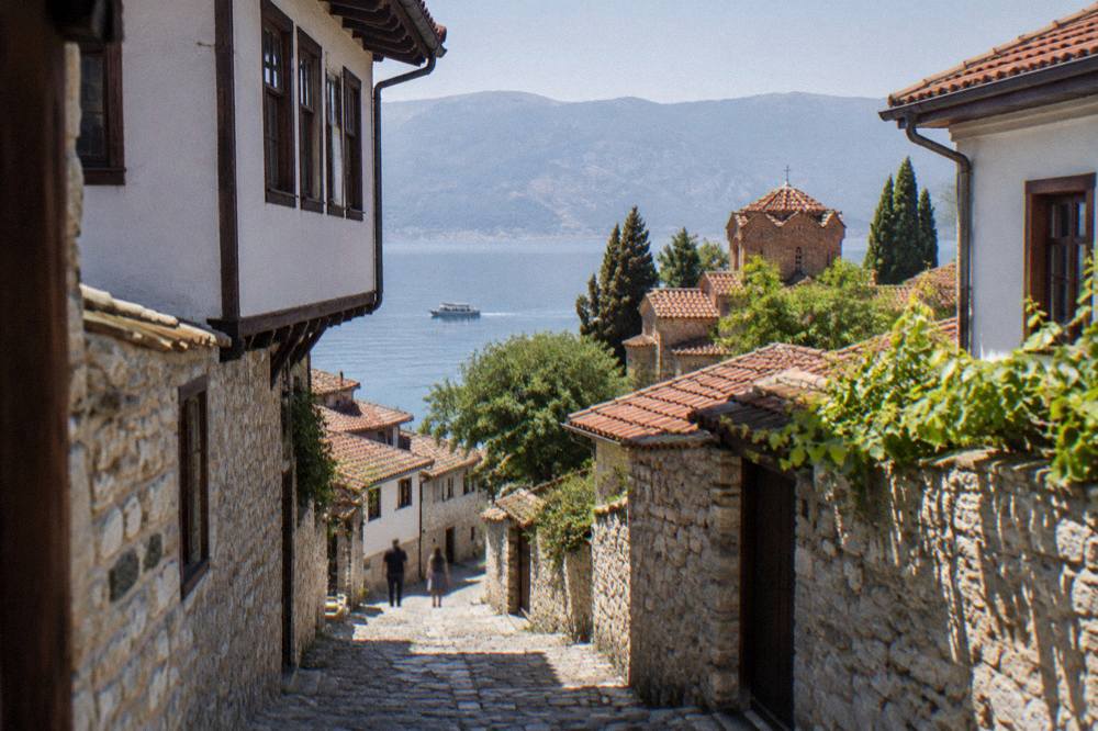 A small boat cruising on calm Lake Ohrid water near Ohrid port