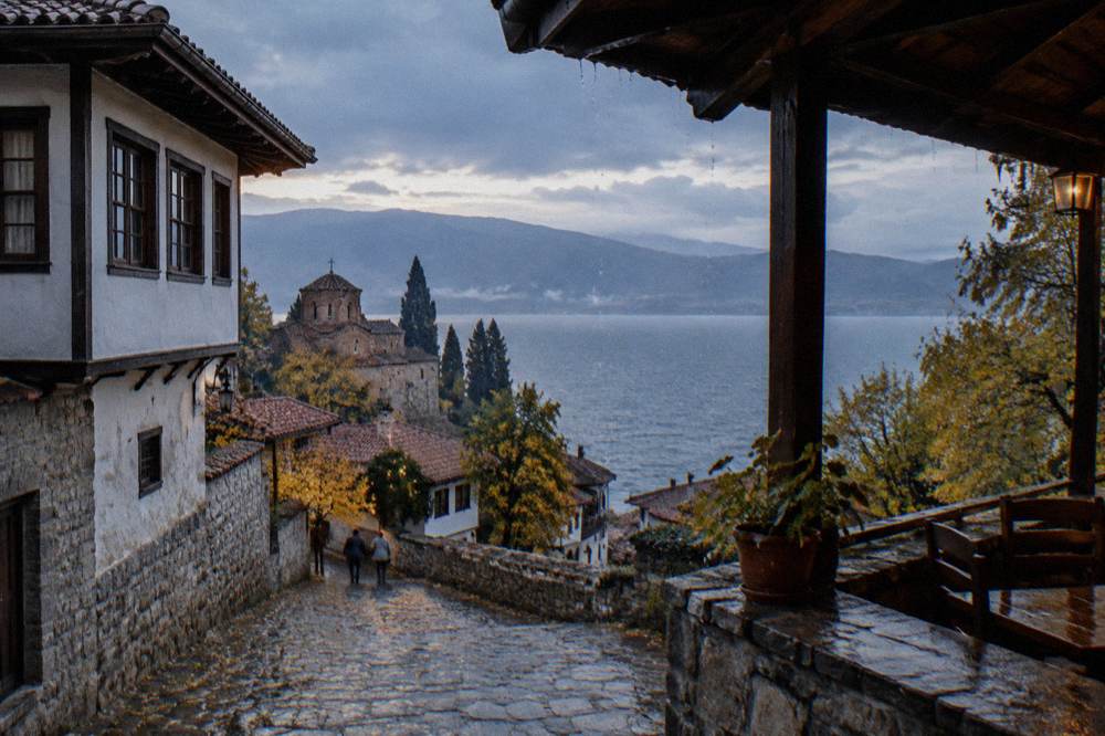 Rain falling on the surface of Lake Ohrid seen from a covered terrace