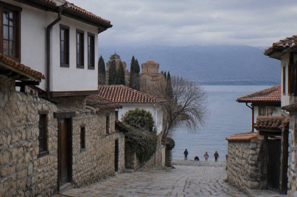 Children playing at the edge of a pebble beach on Lake Ohrid near Ohrid town