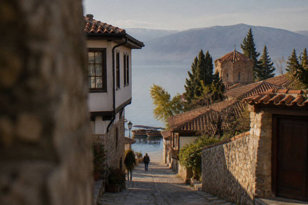 Wooden tour boats moored along the stone quay of Ohrid port on a calm morning