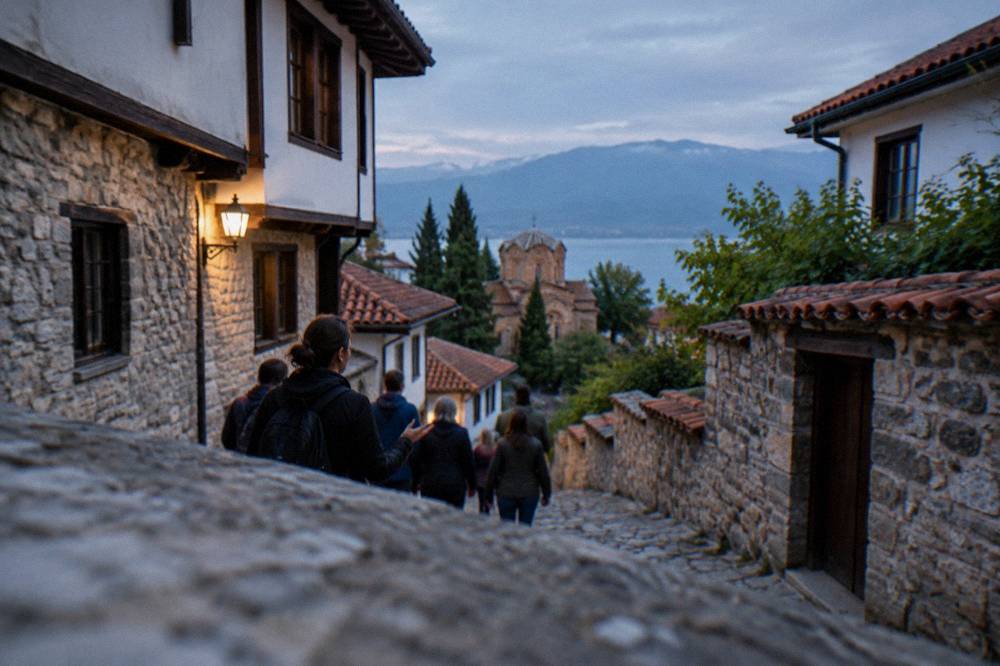 A guide leading a small group along a cobbled Ohrid street lined with old stone houses