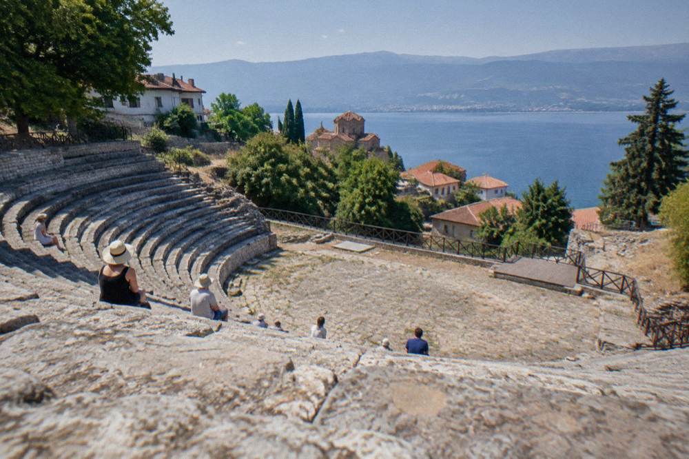 Rows of stone seats in the open-air Ancient Theatre of Ohrid under a clear sky