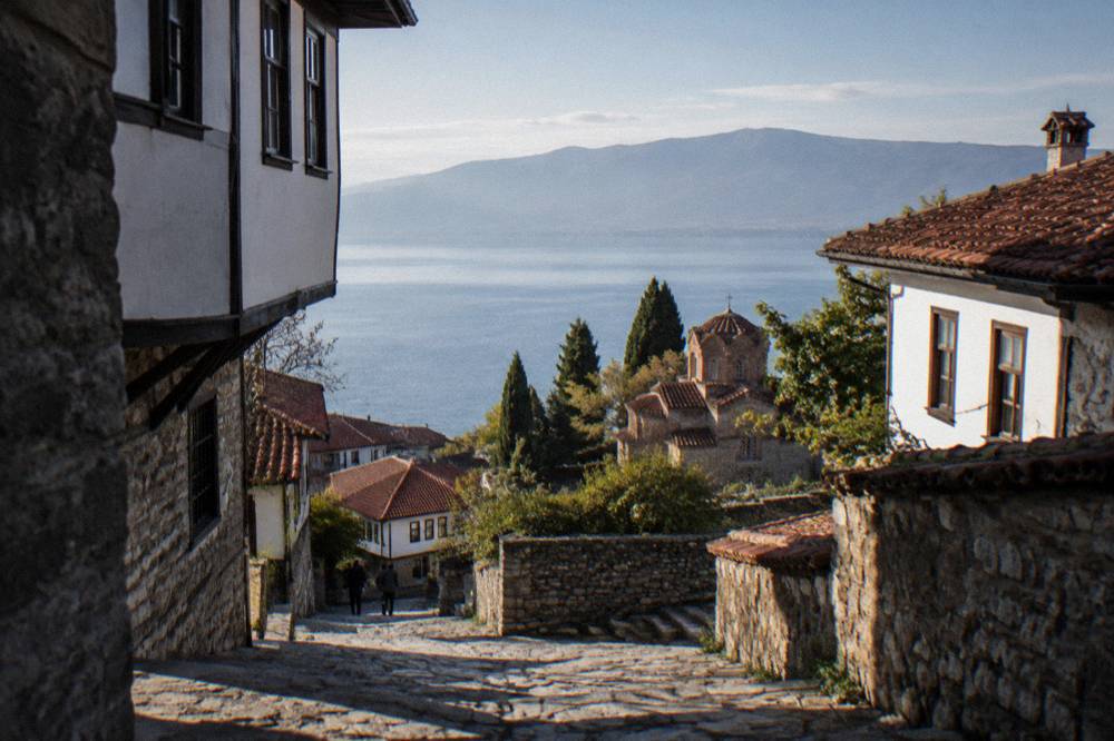 Wide view across Lake Ohrid from high stone walls above red rooftops